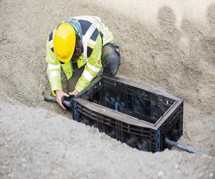 Bauarbeiter beim Einbau eines Langmatz-Kabelschachts